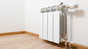 Un radiateur dans une pièce avec un sol en bois.