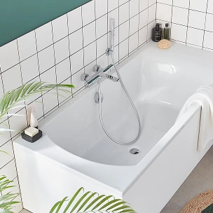 Une baignoire blanche à côté d'une plante verte.