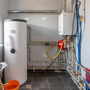 Un chauffe-eau et des tuyaux dans une pièce.