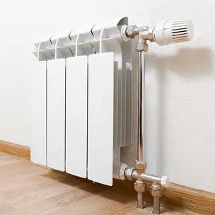 Un radiateur dans une pièce avec un sol en bois.