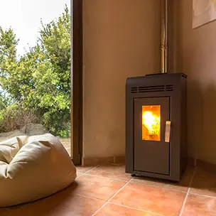 Un salon avec une poêle à granulés et un pouf.